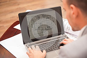 Close-up portrait of laptop with blueprints