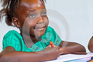 Close up portrait of little african girl holding crayon