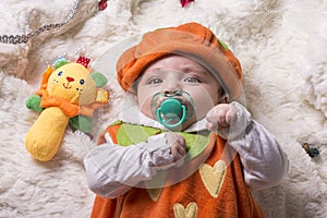 Close-up portrait of a little baby girl with pacifier lying on f