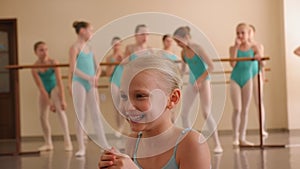 Close-up portrait of a little ballerina in a ballet school.
