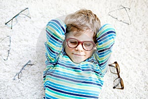 Close-up portrait of little blond kid boy with brown eyeglasses