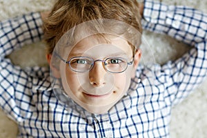 Close-up portrait of little blond kid boy with brown eyeglasses