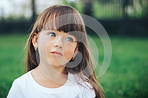 Close up portrait of little dreaming girl with blue eyes