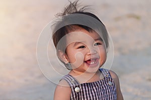 Close up portrait little girl. Cute adorable asian little girl play in park with sun ray background. Happy baby girl play in