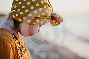 Close-up portrait of little girl on sunset beach