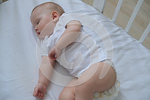 Close-up portrait of a little sleeping baby in a crib.