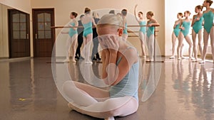 Close-up portrait of a little upset girl in a ballet Studio, she is crying.