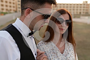 Close up portrait of lovely young couple in elegant clothes and sunglasses