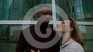 Close-up portrait of a loving couple, an African-American man and a blonde woman, they look at each other affectionately