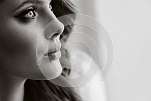 Close-up portrait of a luxurious bride in a wedding dress in the morning in her interior