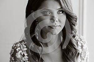 Close-up portrait of a luxurious bride in a wedding dress in the morning in her interior