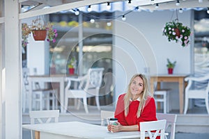 Close-up portrait of magnificent caucasian girl lady wearing red sweater and white skirt. Lovable long-haired blonde woman