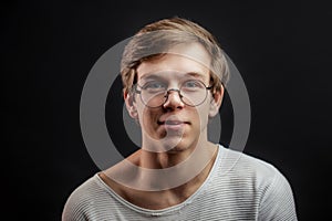 Close up portrait of male tenager in glasses isolated on the black background