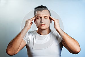 Close-up portrait of a man, covering his face with his hands. On a light background. The concept of body language