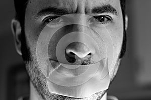 Close up portrait of a man with duct tape over his mouth