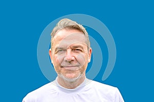 Close up Portrait of a man in his fifties in front of a blue background