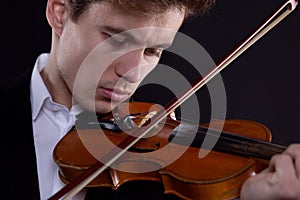 Close-up portrait of a man playing the violin in a live performance