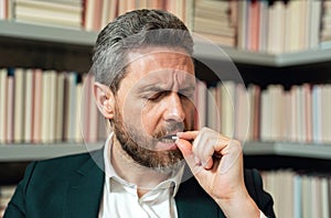 Close up portrait of man taking a medicine pill from headache migraine. Man with sinus headache, tension or cluster