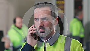 Close up portrait of mature engineer talking on phone in control room
