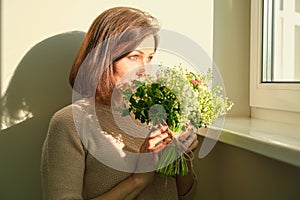 Close up portrait of mature woman with bouquet of flowers