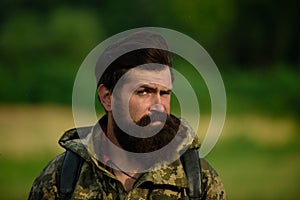 Close up portrait of middle aged farmer bearded man, outdoors in countryside meadow. Man portrait on farmland.