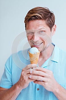 Close-up portrait of middle-aged man eating cone lavender ice cream.