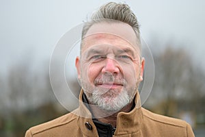 Close up portrait of a middle-aged man in a park in winter or spring