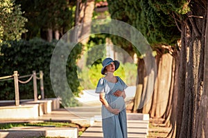 Close up portrait middle aged pregnant woman in pine forest. Concept of travel during pregnancy