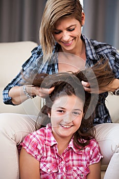 Close up portrait of mother combing her daughter hair