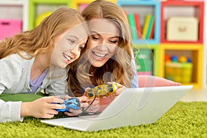 Close up portrait of mother and daughter using laptop together