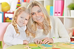 Close up portrait of mother teaches kid to do craft items