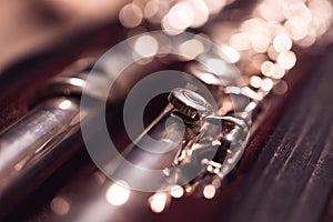 A close up portrait of a music case with a disassembled metal silver flute in it with valves to play notes. the musical instrument
