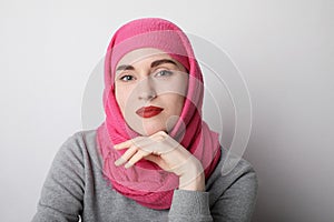 Close-up portrait of a muslim woman wearing a head scarf and smilling. .