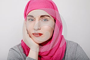 Close-up portrait of a muslim woman wearing a head scarf and smilling. Isolated.