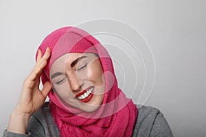 Close-up portrait of a muslim young woman wearing a head scarf and smilling. Isolated.