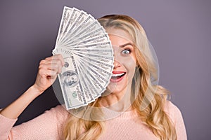 Close-up portrait of nice attractive cheerful crazy overjoyed wavy-haired girl client holding in hands fan of 100 usd