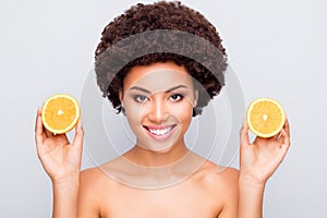 Close-up portrait of nice attractive cheery healthy wavy-haired girl holding in hand orange pieces spa mask rejuvenation