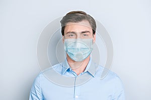 Close-up portrait of nice content guy wearing safety gauze mask influenza risk prevention isolated on gray color