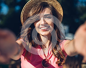 Close up portrait Nice laughing girl in hat making selfie on the beach.Cute summer fashion portrait of beauty brunette woman havin