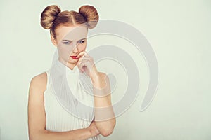 Close-up portrait of offended beautiful girl. with funny hairstyle looking at camera.