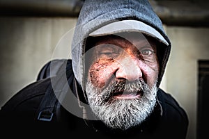 Close up portrait of old homeless alcoholic one eye man face with white beard and hair wandering on the street depressed sick and