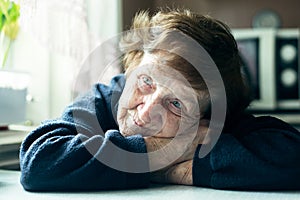 Close-up portrait of old sad woman in her home. Depressed