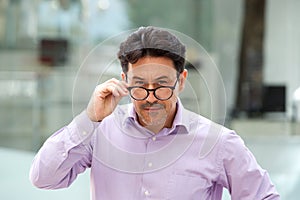 Older man with glasses looking with suspicion