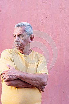 Close up portrait older man leaning against wall and staring