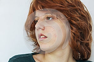 close-up portrait of a pensive teenage girl with red hair with a stylish