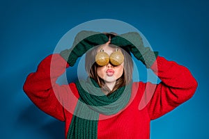 Close up portrait photo of pretty childish young lady send air kiss snowman hold two x-mas baubles hiding eyes wear red