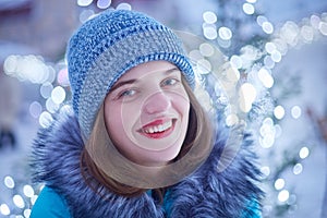 Close up portrait of pleasant looking young woman with blue eyes, red lips, healthy skin, wears warm knitted hat and jacket, spend