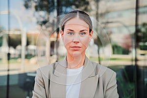 Close up portrait of powerful business woman looking serious at camera standing at workplace. Elegant office secretary
