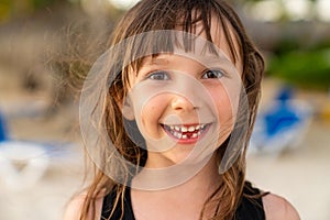 A close-up portrait of a pretty 6 year old girl with one missing tooth. Funny toothless smile