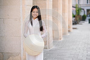 Close up portrait of pretty asian girl dressed in Ao Dai dress with vietnamese conical hat.